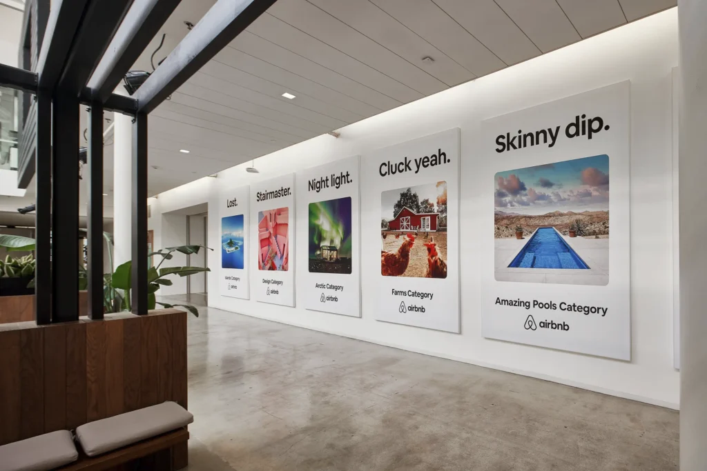 Heller, moderner Flur im Hauptsitz von airbnb mit großen Textilspannrahmen im Corporate Design an der Wand