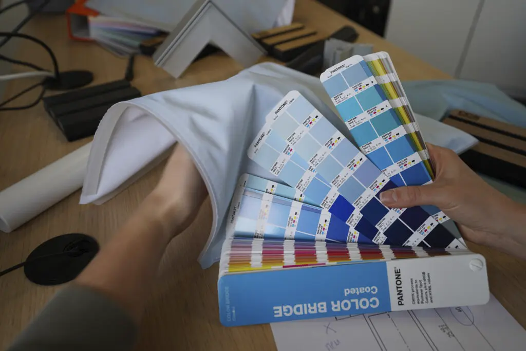 Abgleich einer Textildruckfarbe mit einem aufgeschlagenen Pantone Farbfächer